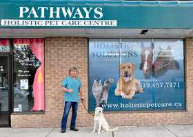 Photo of Dr Stewart in front of his office with a dog on a leash